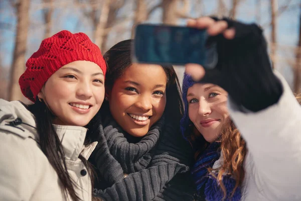 Grupo de amigas gostando de tirar selfies na neve no inverno — Fotografia de Stock