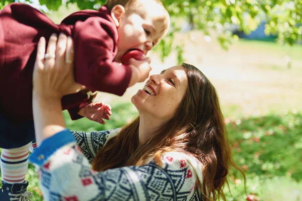 Cute young female toddler biting into organic apple sitting on l — Stock Photo, Image