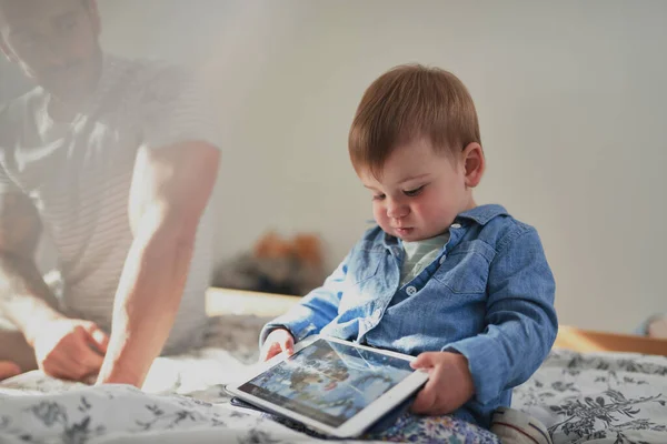 Kleinkind spielt mit Jeans auf digitalem Tablet — Stockfoto