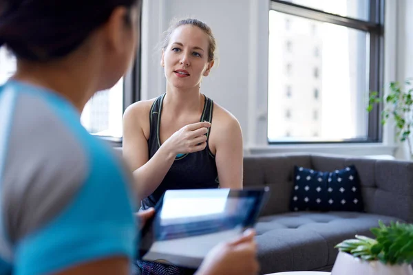 Chinese woman physiotherapist talking to a mid-adult caucasian f — Stock Photo, Image