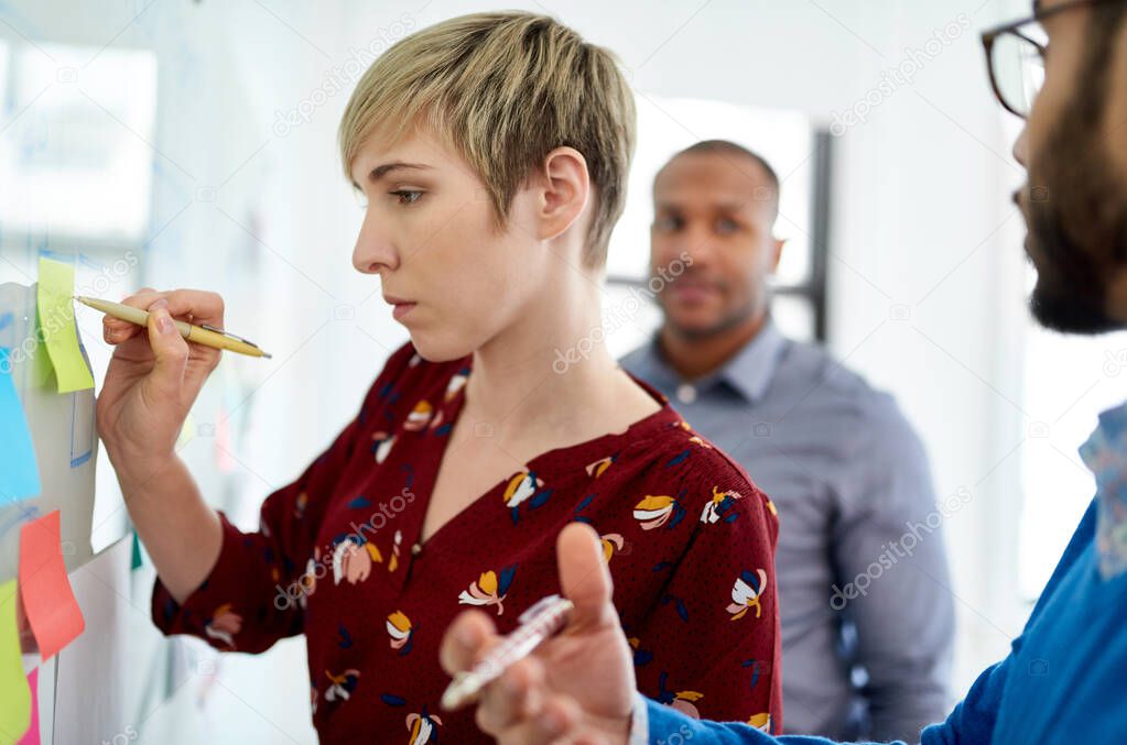 Portrait of a blonde short hair woman leading a diverse team of creative millennial coworkers in a startup brainstorming ideas