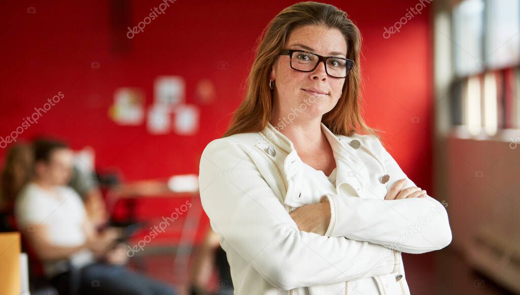 Confident female designer working in red creative office space