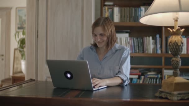 Junge brünette Frauen arbeiten am Laptop am Holztisch im klassischen Interieur — Stockvideo