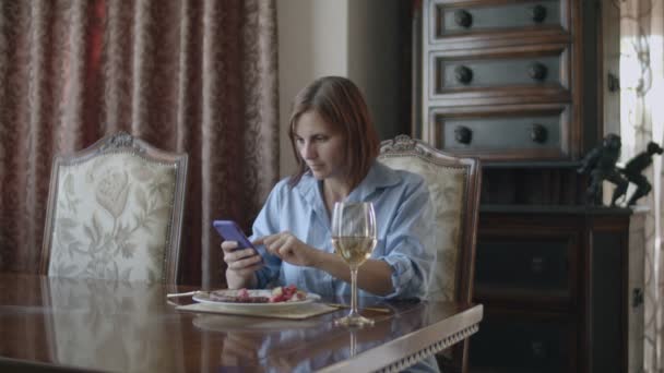 Brünette Frauen, die mit Kreditkarte und Smartphone einkaufen, während sie im klassischen Interieur essen — Stockvideo