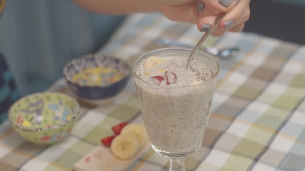 Zbliżenie podejmowania wegańskie pudding Chia z orzechów i owoców w zwolnionym tempie — Wideo stockowe