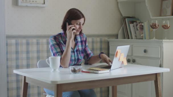 Young female freelance working at home. Brunette women talking online sitting at the table in provence interior. — Stock Video