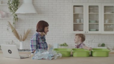 Anne ve oğlu geri dönüşüm için plastik ve cam atık ları ayıklama. Toddler plastik geri dönüşüm öğrenme. Çevre dostu aile çevre tasarrufu. 