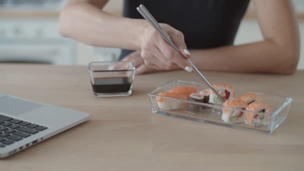 Mujer morena joven comiendo sushi en la cocina luminosa. Europea hembra comer japonés comida . — Vídeos de Stock