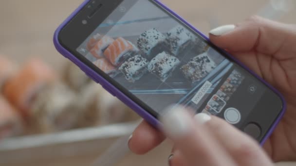 Jonge brunette vrouw eten sushi op lichte keuken. Europese vrouwelijke eten Japans eten. — Stockvideo