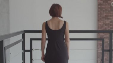 Yavaş çekimde kameraya gülümseyen siyah elbiseli genç güzel kadınların portresi