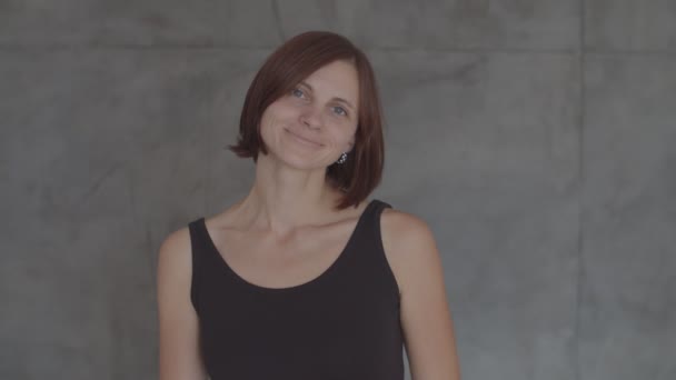 Portrét mladých hezkých žen v černých šatech usmívaje se s kamerou v pomalém pohybu — Stock video