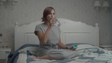 Gri elbiseli, genç ve güzel kadınların, Provence 'ın iç kısımlarında yatağın üzerinde oturup içme suyu içmeleri yavaş bir harekettir.. 