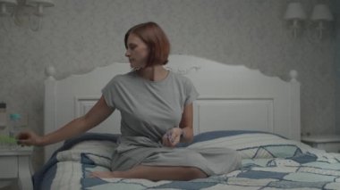 Gri elbiseli genç ve güzel kadınların, Provence 'ın iç kısımlarında yatağın üzerinde oturup haplar ve vitaminler almaları yavaş bir harekettir.. 