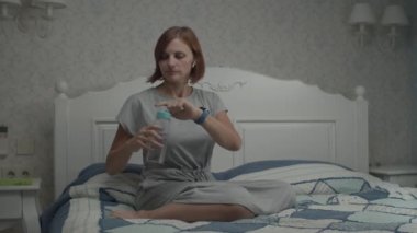 Gri elbiseli genç ve güzel kadınların, Provence 'ın iç kısımlarında yatağın üzerinde oturup haplar ve vitaminler almaları yavaş bir harekettir.. 