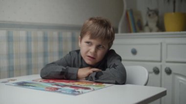 Autistic kid completing last pieces of jigsaw puzzle on the table in slow motion. Child with autism solving puzzle jigsaw. Autism awareness