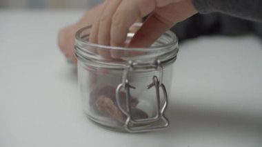 Close up of kids hand taking healthy snacks from glass bowl in slow motion. Healthy food concept. 