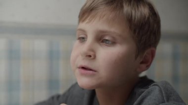 Masada ağır çekimde sağlıklı atıştırmalıklar yiyen otistik çocuklara yakın çekim. Çocuk yiyecekten memnun. Otizm farkındalığı 