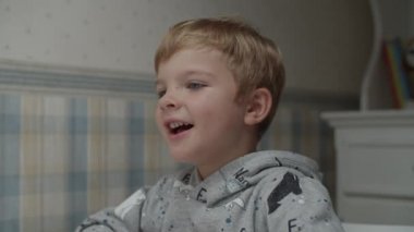 Sarışın çocuğun sağlıklı yiyecekler yediği ve ağır çekimde şarkı söylediği yakın plan.. 