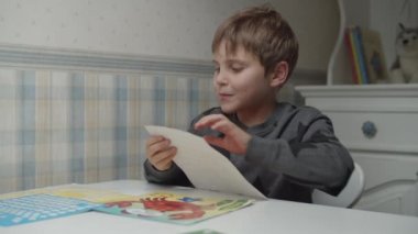 Otistik çocuk renkli çıkartmalarla oynuyor. Otizmli çocuk çıkartmalardan şekil ve renk öğreniyor. Otizm farkındalığı 