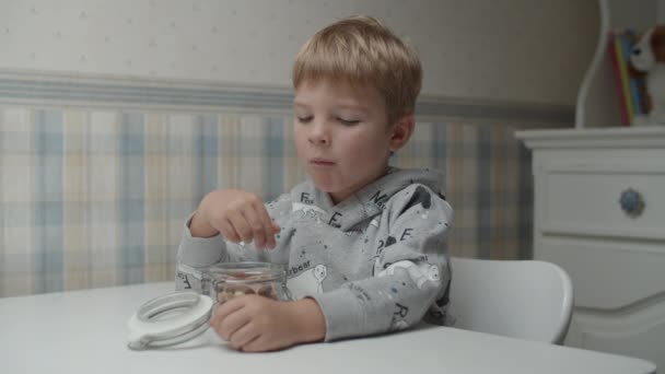 Ragazzo biondo che mangia spuntini sani e trova la pace del cibo che non gli piace. Bambini infelici faccia mentre mangiano al rallentatore . — Video Stock