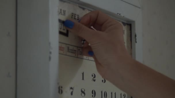 Женщины вручную меняют даты на стенах магнитного календаря в замедленной съемке. Установка даты 12 июля, вторник в календаре . — стоковое видео
