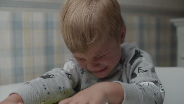 闷闷不乐的金发男孩慢吞吞地哭着。 哭哭啼啼的孩子不快乐. — 图库视频影像