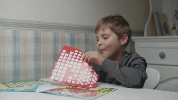 Rapaz autista a brincar com autocolantes coloridos. Criança com autismo aprendendo formas e cores por adesivos. Consciência do autismo — Vídeo de Stock