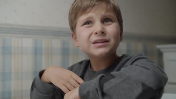 Niño autista comiendo bocadillos saludables en cámara lenta sentado en la mesa. El chico está contento con la comida. Conciencia del autismo — Vídeos de Stock