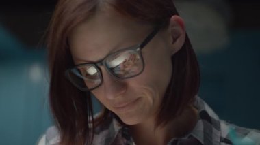 Gözlüklü 30 'lu yaşlardaki genç bir kadın evde bozuk paraları sayıyor. Gece para sayan bir kadın. Kadın gözlüğündeki yansıma.. 