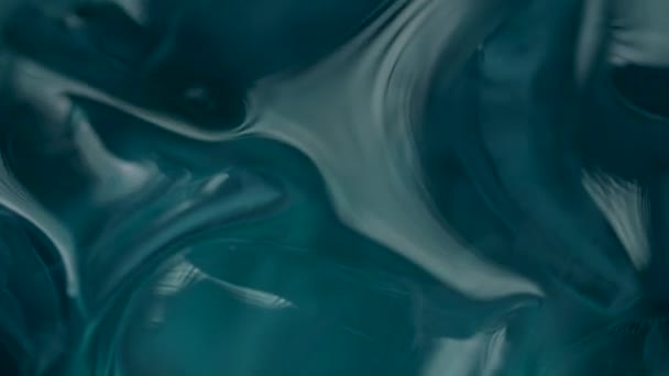 青いガラスで回転する水の中の氷のキューブのマクロビュー。青い光の中でゆっくりと動き回る水と氷の閉じ込め. — ストック動画