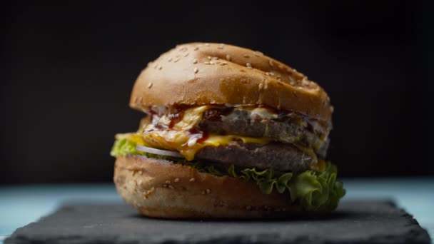 Finom burger dupla marhahússal, olvasztott sajttal, salátával és zöldséggel, eredeti alakját öltve, lassított felvételű tömörítés után. — Stock videók