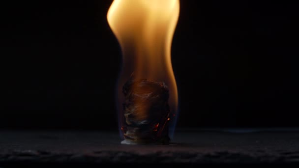 Kindle fire using wood chips roll on black background. Burning fire indoors in slow motion. — Stock Video