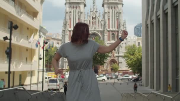 Giovane donna anni '30 felice adulto in abito grigio ballare in centro molto emotivo. Donna gode di ballare, ascoltando la musica in auricolari wireless. — Video Stock