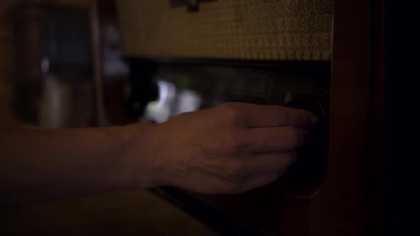 Vrouwelijke hand die vintage radio aanzet. Ouderwetse radio melodie. — Stockvideo