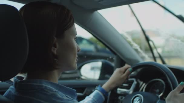 Giovane donna anni '30 alla guida di auto in città. Vista laterale del conducente femmina che tiene il volante. — Video Stock