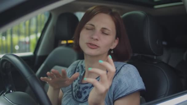 Νεαρή 30άρα που χορεύει και τραγουδάει στο αμάξι. Πλευρική άποψη του γυναικείου οδηγού χορό με τα χέρια. — Αρχείο Βίντεο