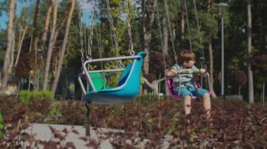 Lunaparkta renkli bir şöföre binen iki çocuk. Kardeşler parkta yalnız eğleniyor. Karantina sırasında sosyal uzaklık. 