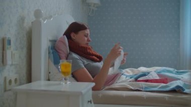 Yatakta yatan hasta genç bir kadın. Burnu akmaktan yorulmuş. Öksürüğünde sıcak atkısı olan ve burnunu peçeteyle silip atan kadın. Grip ve diğer solunum hastalıkları.