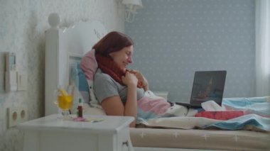 Genç hasta anne oğluyla internette konuşuyor. Evde dizüstü bilgisayar kullanıyor. Çocuk internette hasta anneyi doğum günüyle kutluyor. Virüs hastalığı sırasında sosyal uzaklık. 