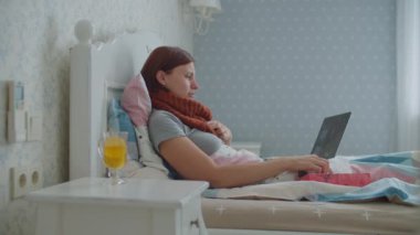 Hasta genç bir kadın yatağında dizüstü bilgisayarla konuşuyor. Boynunda eşarpla öksüren, burnunu silip internette sohbet eden bir kadın. Evde grip ve diğer solunum hastalıkları.