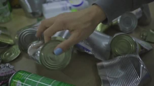 Молодая 30-летняя женщина в защитной маске сортирует отходы, такие как металлические банки, пластиковые и стеклянные бутылки. Экономия окружающей среды, сокращение потребления пластика. Концепция нулевых отходов. — стоковое видео
