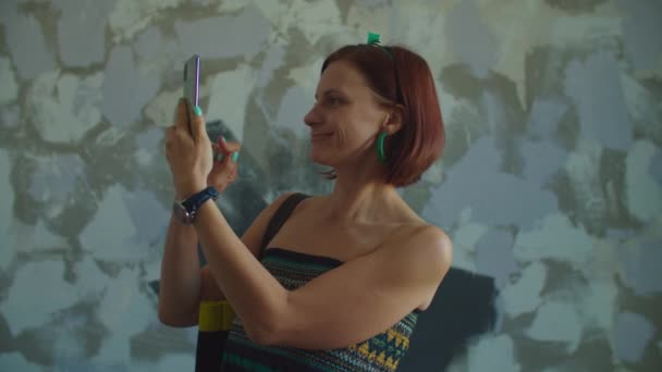 30άρα γυναίκα με φόρεμα φωτογραφίζει την ανακαίνιση του σπιτιού στο κινητό τηλέφωνο. Ευτυχισμένη γυναίκα ονειρεύεται εσωτερική διακόσμηση για το νέο της διαμέρισμα. — Αρχείο Βίντεο