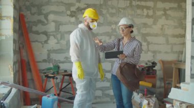 Tadilat planında çalışan kadın mühendis ressam elinde planlı tablet bilgisayarı tutuyor. Ev yenileme süreci.