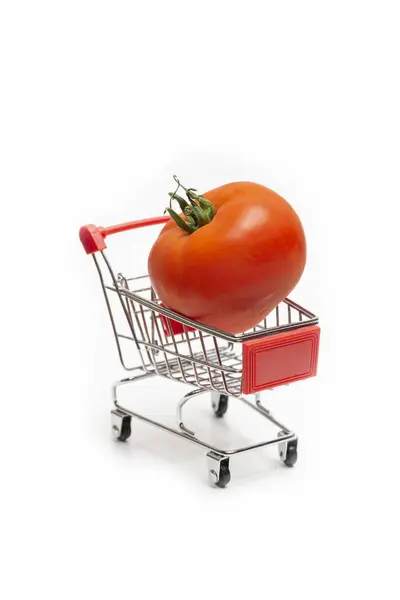 白い背景に分離された小型スーパー カートに読み込まれている大きな赤いトマト — ストック写真