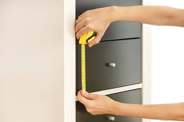 Female Hands Measuring The Height Of Drawers With An Automatic Tape Measure