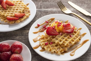 waffles with strawberries on a white plate on a white background with golden fork and knife clipart