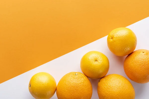 Renkli kağıt arkaplanındaki portakallar