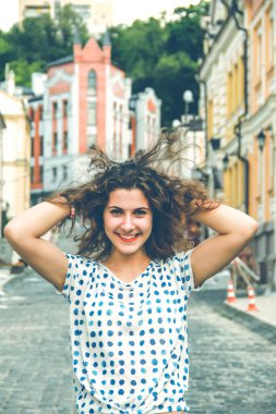 Genç güzel kız gün ışığında sokakta yürüyor.