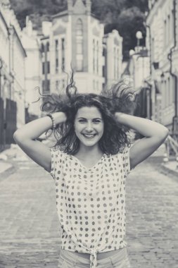 Genç güzel kız gün ışığında sokakta yürüyor.