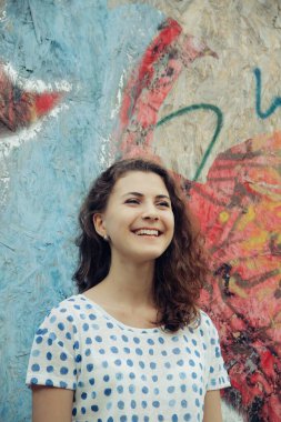 Genç güzel kız gün ışığında sokakta yürüyor.